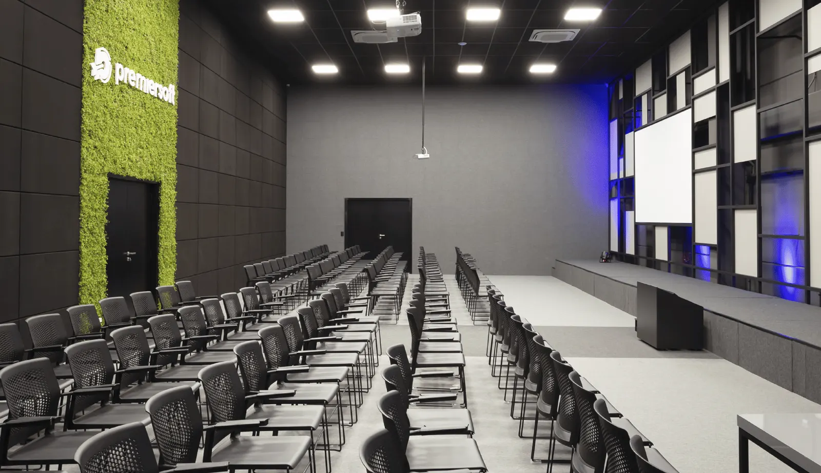 Auditório da Premiersoft visto do fundo, com palco, telão e plateia montada